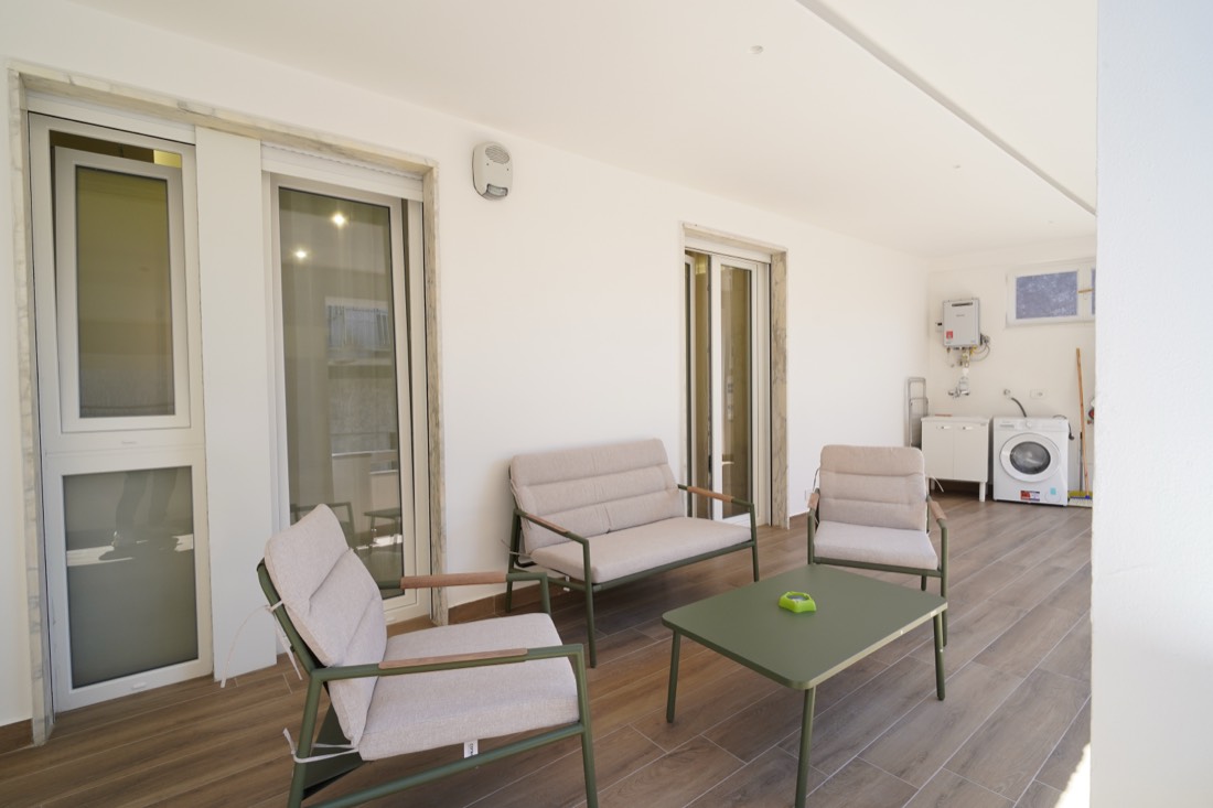 Terrazza coperta con più porte finestre e zona lavanderia