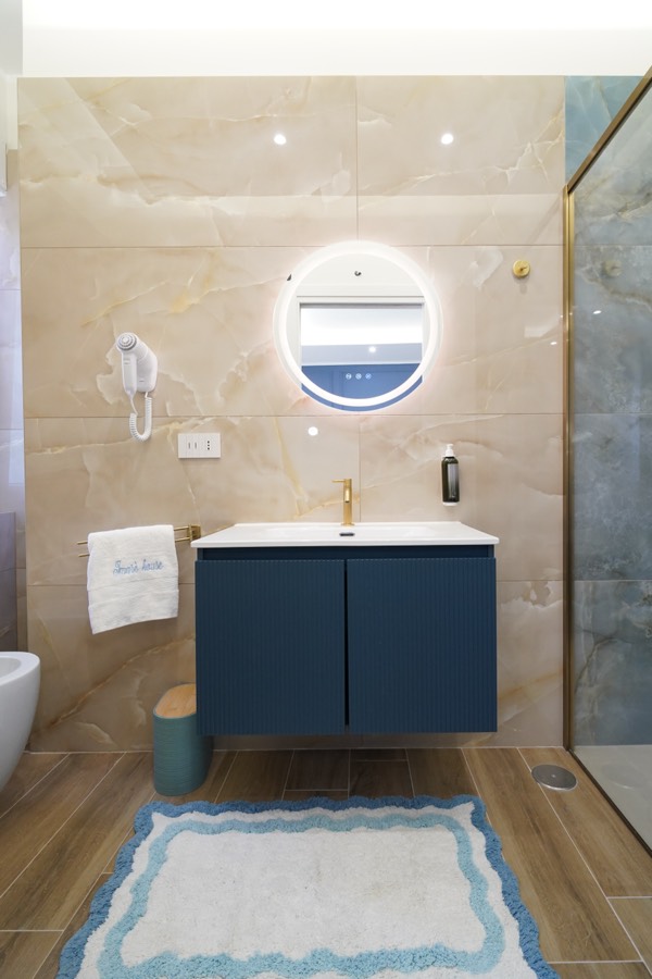 Bagno privato della Camera Iris con doccia, marmo onice blu e specchio tondo